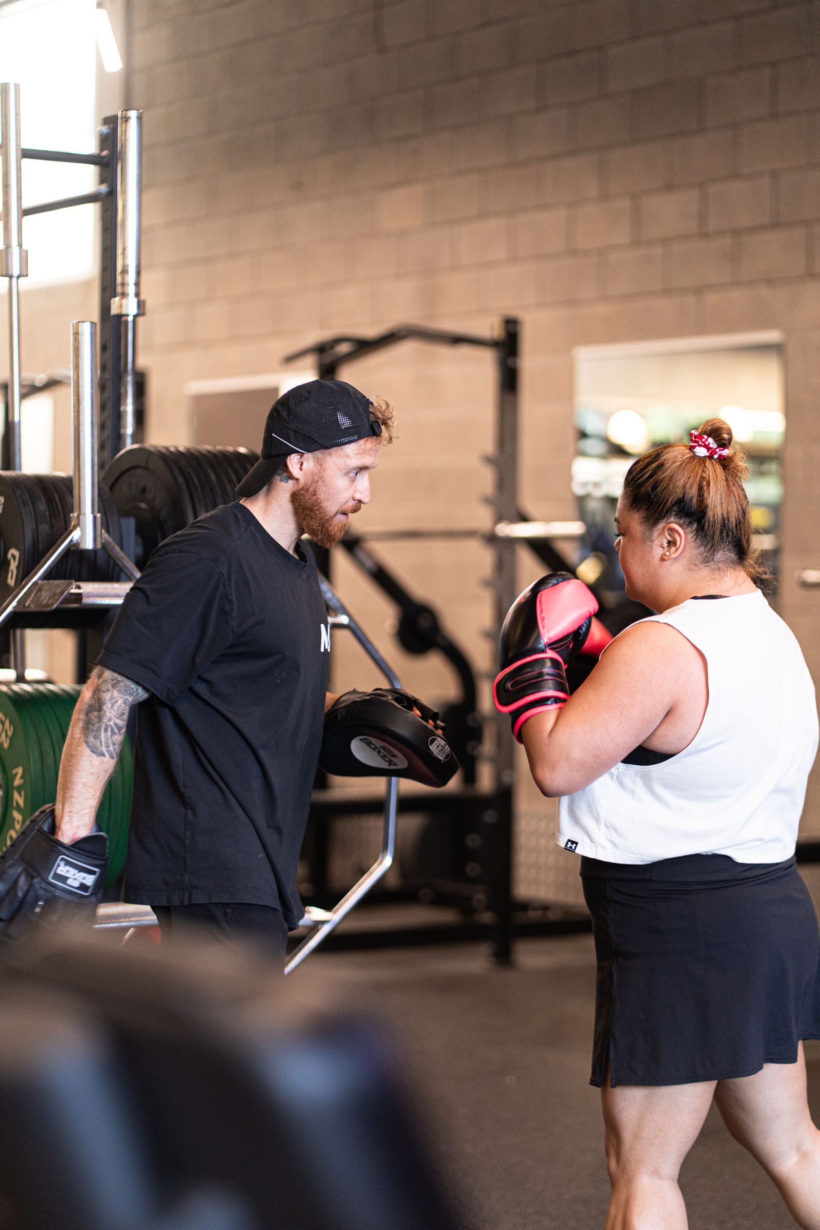 An M2 coach running a pad work PT session with a member in Grafton
